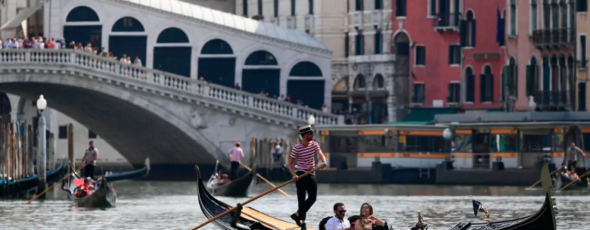 A gondolier with tourists on the Canal Grande CBC News | James Alexander Michie