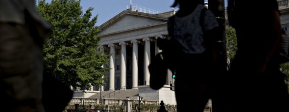 Pedestrians walk near the U.S. Treasury building Bloomberg | James Alexander Michie