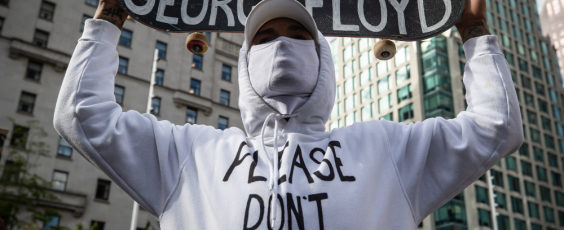 A man holds a skateboard bearing George Floyd's name National Post | James Alexander Michie